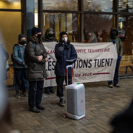 A couple of SLAM members speaking outside of a TAL office.