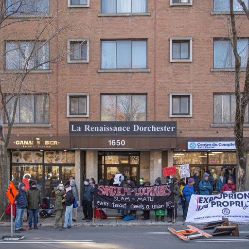 Several SLAM members outside an apartment building, picketing a nefarious landlord